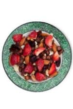Fresh mixed berry and nut salad on a green plate, vibrant and healthy.