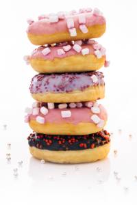 Delicious assorted donuts with pink icing, sprinkles, and colourful toppings, perfect for snacks or.