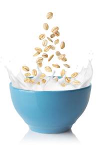 Fresh coffee beans spilling into a blue bowl, ideal for grocery shopping and cupboard essentials.
